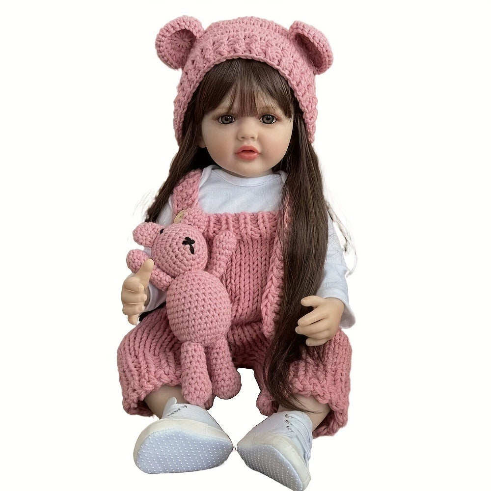 Doll wearing a pink outfit with a hat and holding a teddy bear on a white background